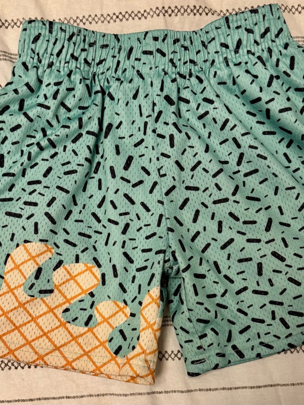 Kids Aqua Patterned Swim Shorts with Orange Wave Accent